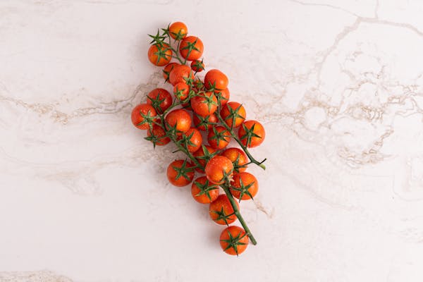 Overhead view of vibrant cherry tomatoes on a marble surface.